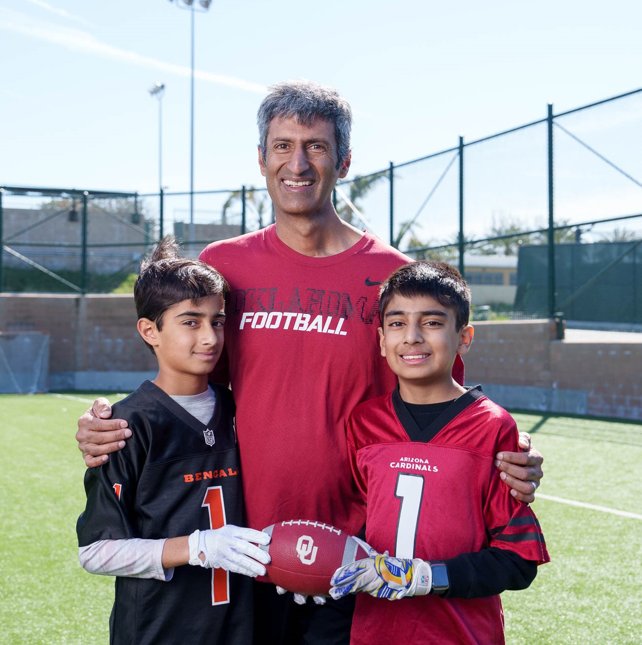 Sahil, Ankush and Sachin Chhabra enjoy tossing the football around on the Mira Costa High School field near their home.