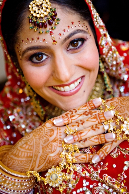 Sarina Brai Pai, CO, on her wedding day wering a North Indian-style embroidered lehenga, her hands decorated with henna and her eyes and head adorned with bindis and jewels capturing the essence of a traditional Indian bride.